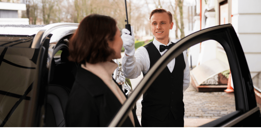 A driver holding an umbrella over a customer